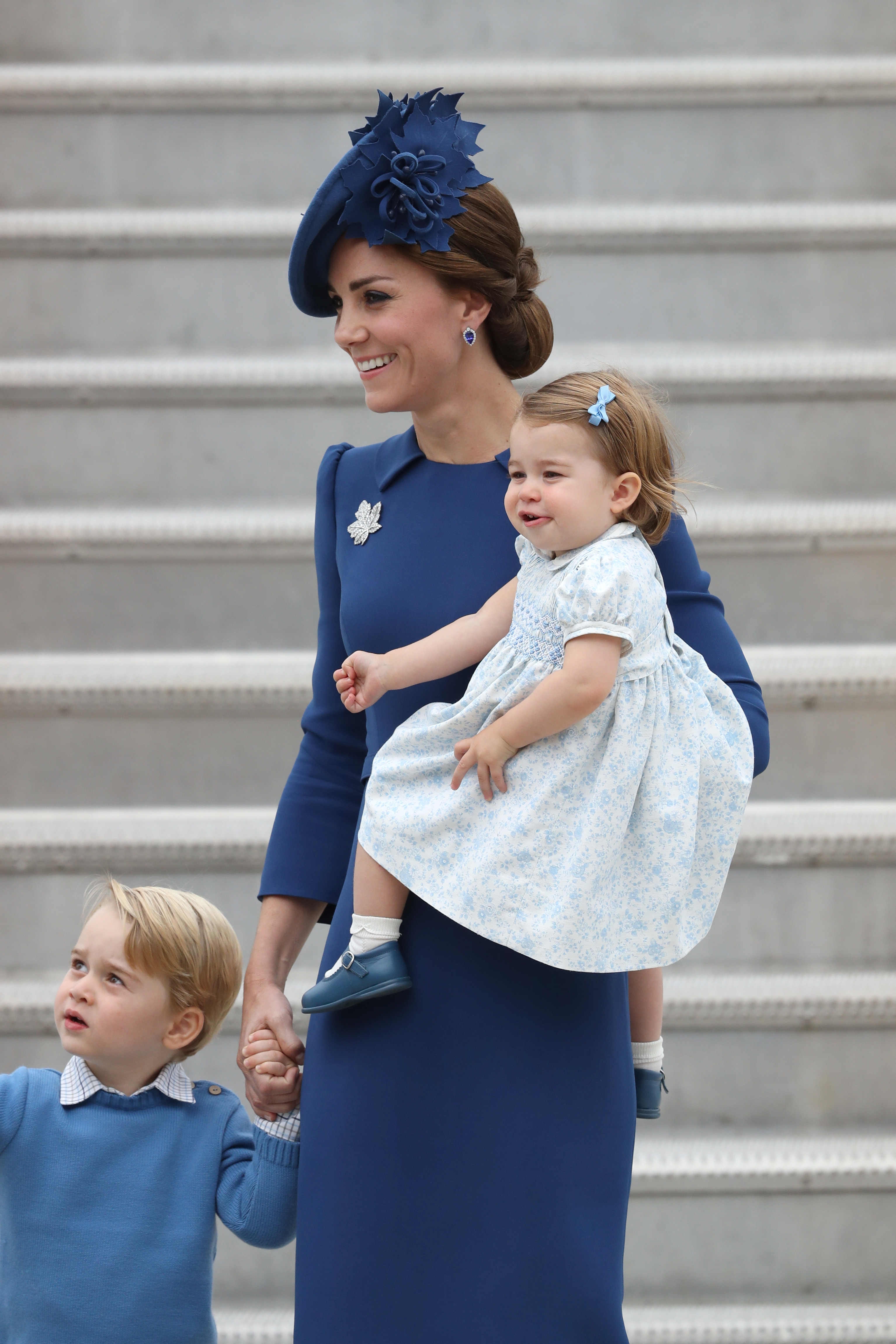 Kate Middleton, George e Charlotte usam look combinandinho Kate Middleton, George e Charlotte apostam em tons abertos de azul para a chegada da família ao país. Foto: