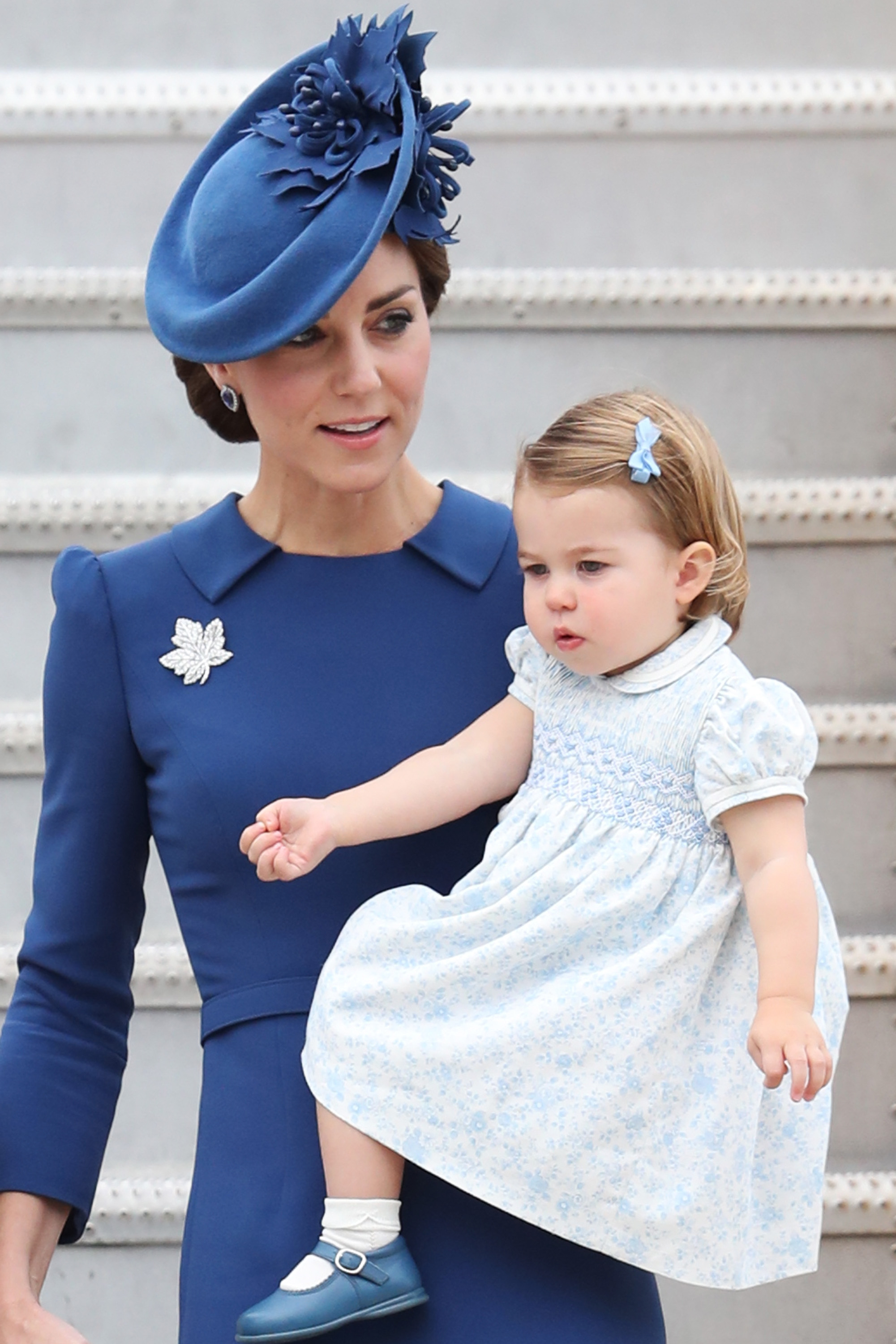 Kate Middleton, George e Charlotte usam look combinandinho A princesa Charlotte apareceu em um vestido floral azul bebê e ficou ainda mais fofa com lacinho no cabelo! Foto: