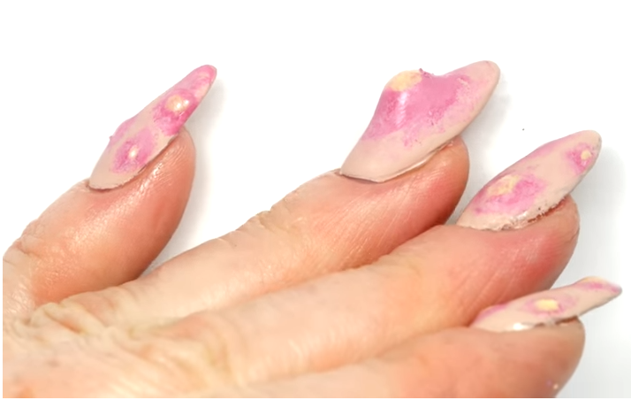 nail-arte-espinha Foto mostra, em um fundo branco, unhas com nail art que imita espinhas.