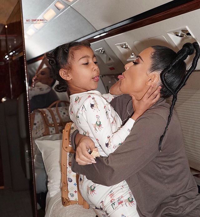 North West e Kim Kardashian abraçadas, elas estão se olhando e mostrando a língua uma para a outra