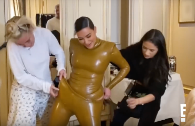 Kim Kardashian tentando vestir roupa de latex