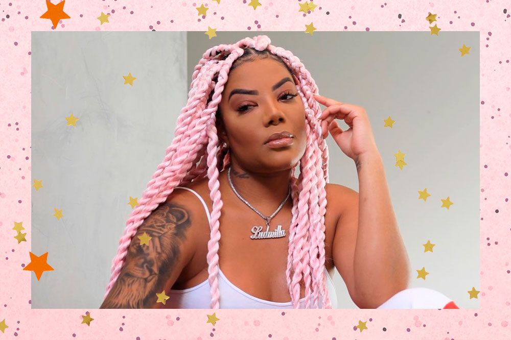 Ludmilla posando para foto com mão no rosto, regata branca e tranças rosa