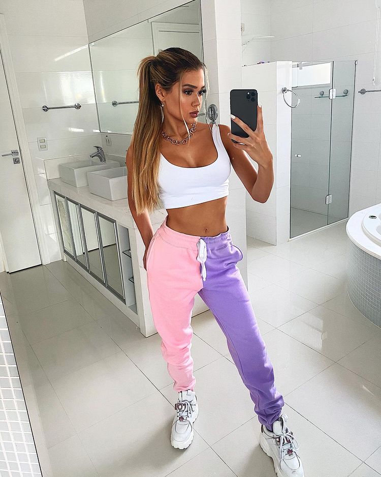 look-candy-color-francinyehlke Influenciadora Franciny Ehlke usando top branco com calça de moletom metade rosa e metade lilás e tênis branco