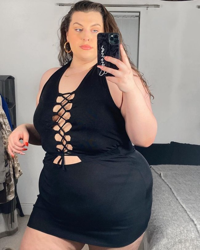 tendencia-polemica-recortes-emmatamsinhill garota usando short e regata pretos. A blusa é amarrada por meio de uma fita na região do colo, dos seios e da barriga