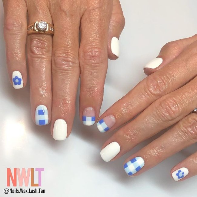 nail art xadrez azul Foto de duas mãos com anel no dedo anelar da mão direita. Ambas as mãos estão com uma nail art xadrez azul e branco.