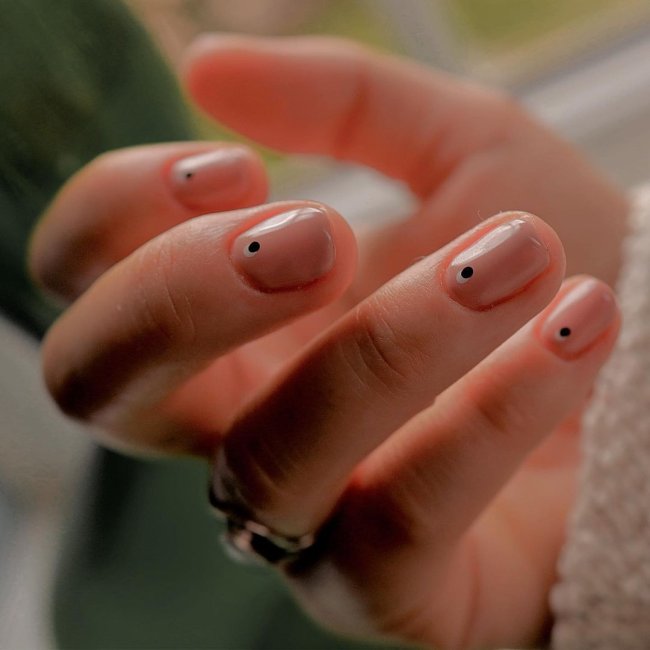 Foto com destaque nas unhas com nail art de bolinha, dessa vez nas cores preto e branca.