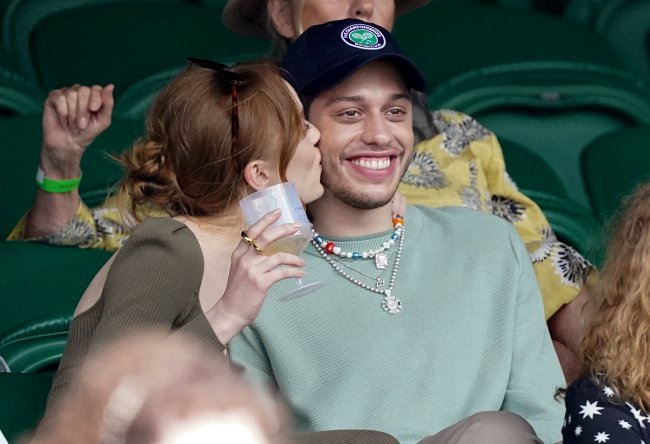 Wimbledon Celebrity Sightings – Day 6 Phoebe Dynevor da beijo na bochecha de Pete Davidson, que exibe um largo sorriso