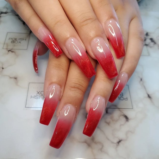 unha vermelha em degrade Foto com foco nas mãos exibindo a nail art das unhas. No caso, unhas vermelhas com degrade de cor