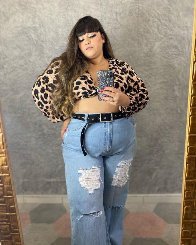 wide leg com animal print Jovem tirando selfie em frente a espelho usando top com animal print e calça wide leg.