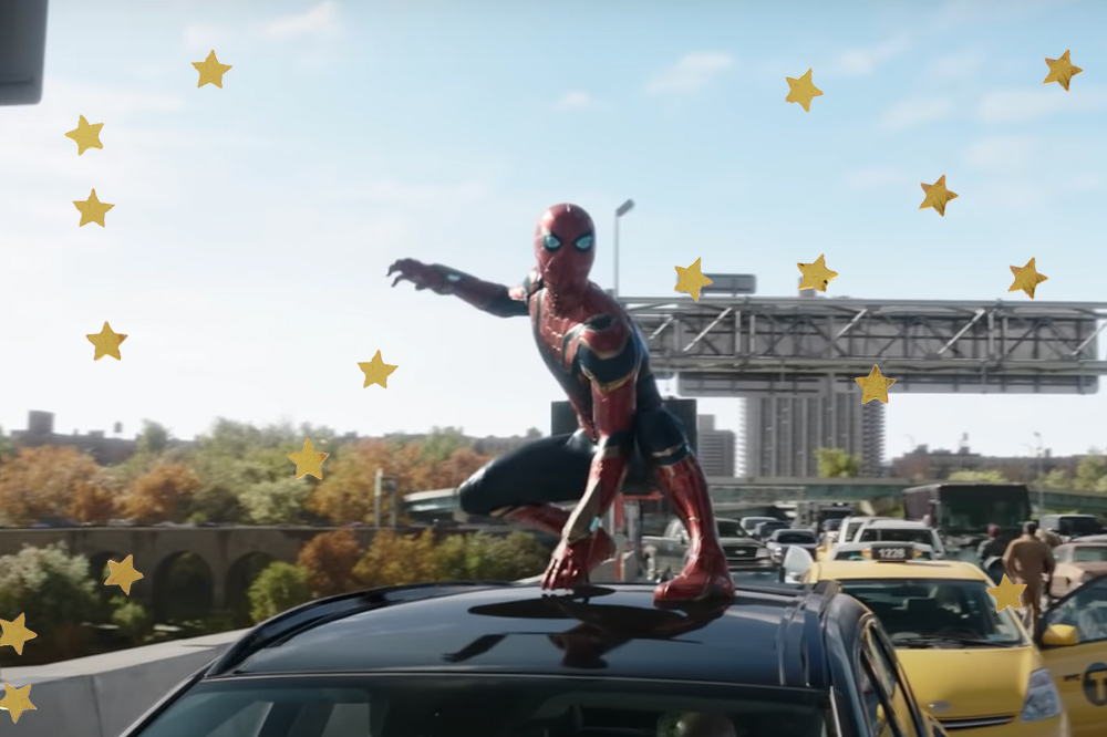 Homem-Aranha, do Tom Holland, em cena de Homem-Aranha: Sem Volta Para Casa com o traje de Aranha em uma posição de luta na parte de cima de um carro preto em uma rodovia com outros carros ao fundo e céu azul claro no último plano da foto; estrelas amarelas são usadas como decoração da imagem