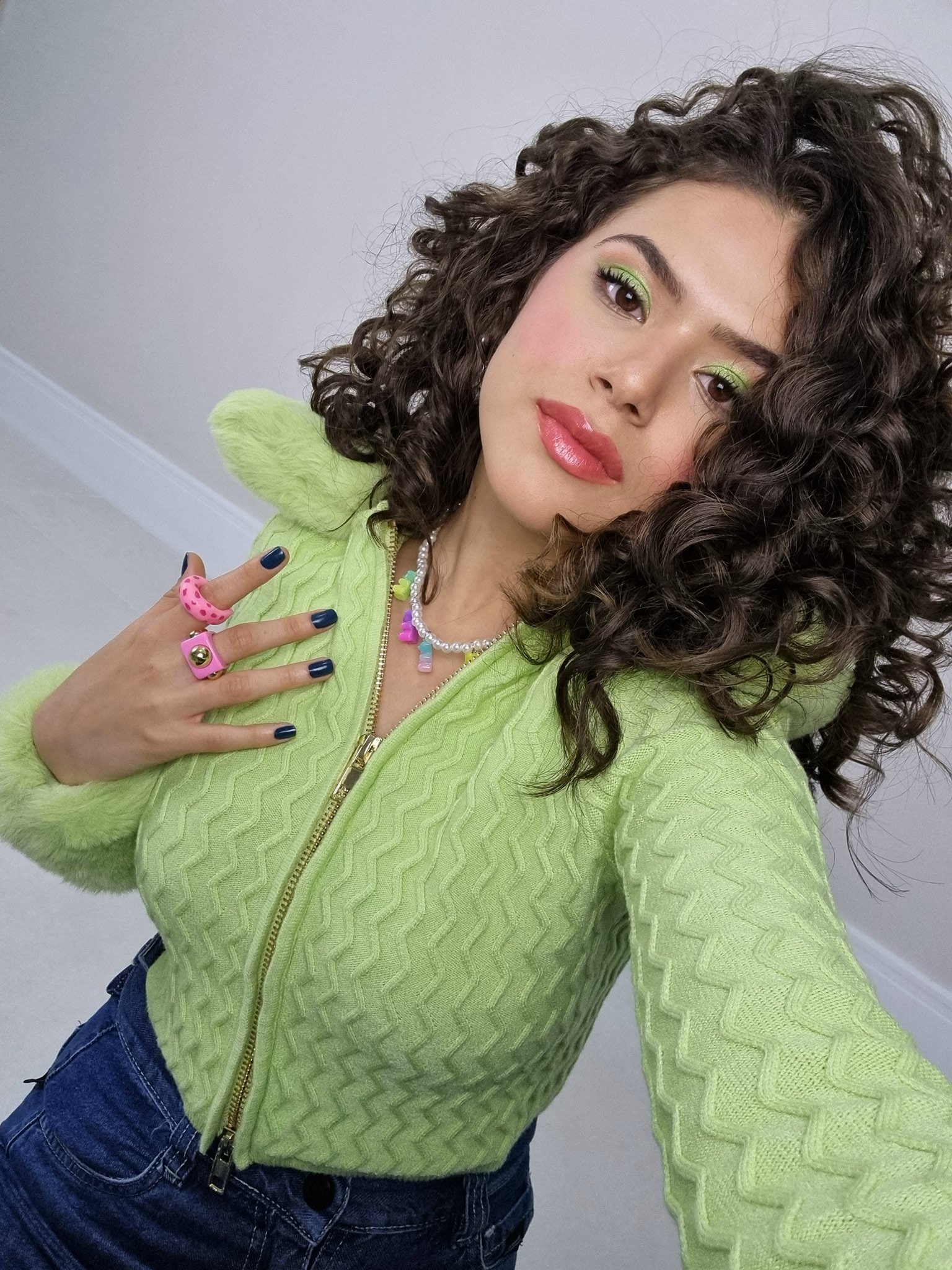 Maisa Silva usando cardigan verde, colar de miçangas e anéis chunky