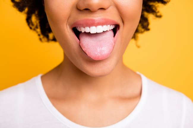 Foto de uma menina negra com a língua de fora. Não dá para ver os olhos dela, pois a foto está cortada