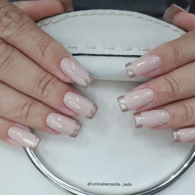 Foto com foco nas unhas feitas com francesinha de glitter.