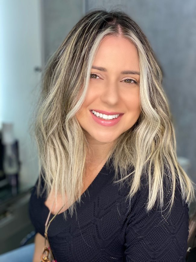 Corte realizado pelo Leo Mathias (2) Jovem sorridente usando blusa preta. Na imagem, só vemos seu rosto e sua blusa preta.