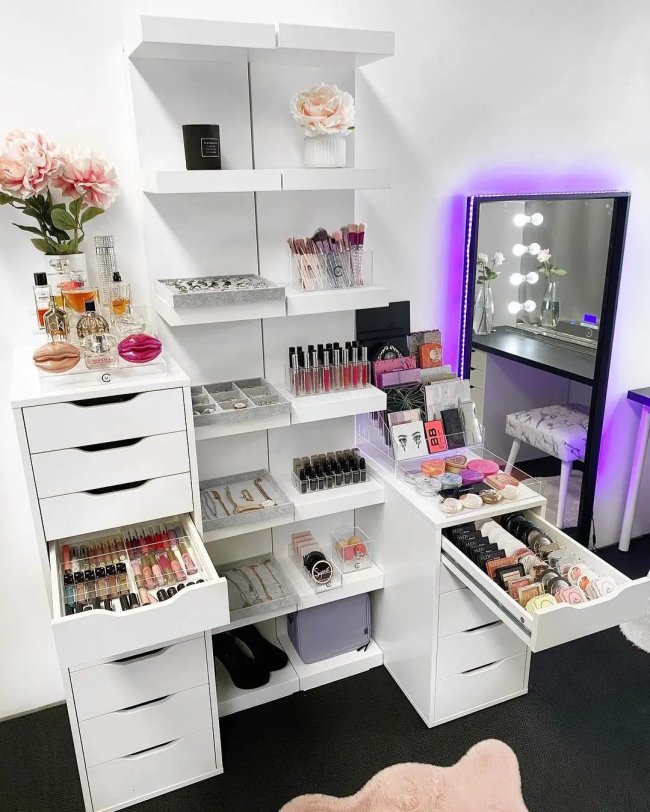 GAVETAS COM MAQUIAGEM Imagem de uma penteadeira estilo camarim com as gavetas abertas e cheias de produtos de beleza.