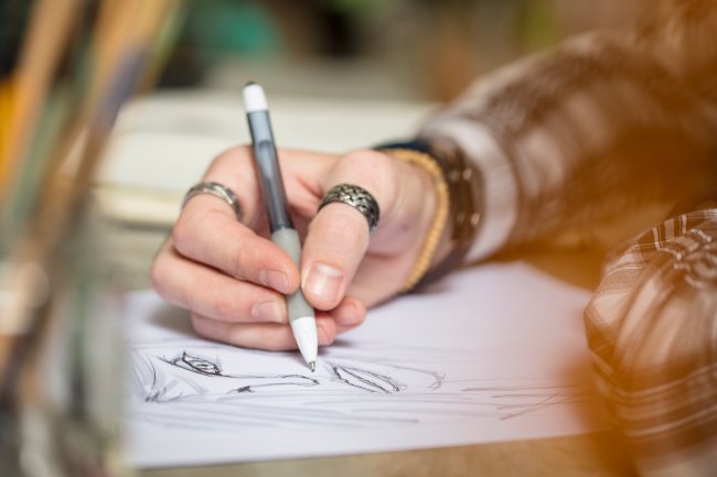 Artista desenhando Mão de artista desenhando rosto em papel