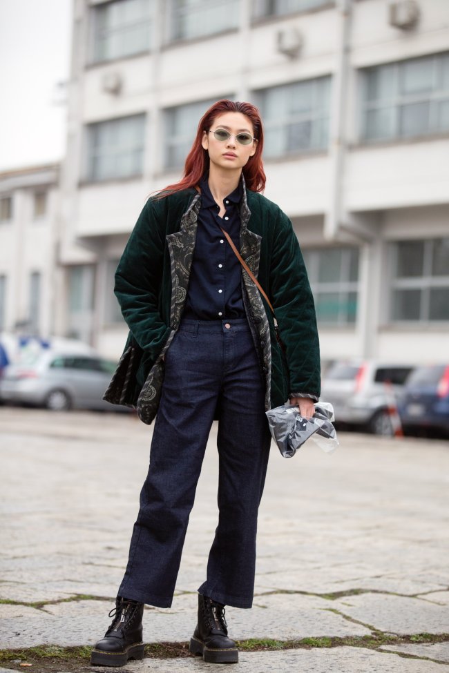 Jung Ho-yeon posando com óculos escuros, expressão séria e parada no meio da rua.