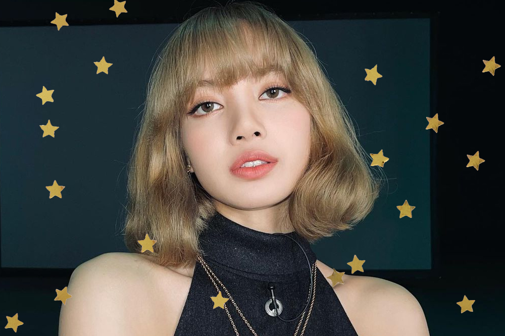 Lisa, do BLACKPINK, com o cabelo loiro curto com franja; ela está olhando para câmera com expressão neutra e usa uma blusa preta sem magas de gola alta com colares dourado e um microfone de lapela (pequeno/mini) preto preso próximo ao pescoço