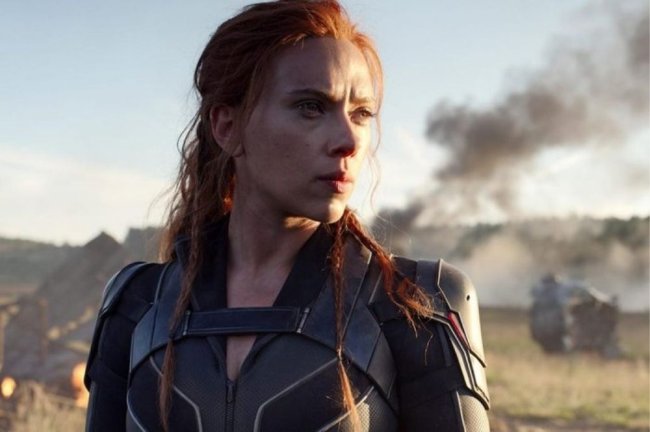 scarlett Foto da atriz Scarlett Johansson como Viúva Negra durante filme. Nela, Scarlett aparece olhando para o horizonte em um campo com fumaça preta.