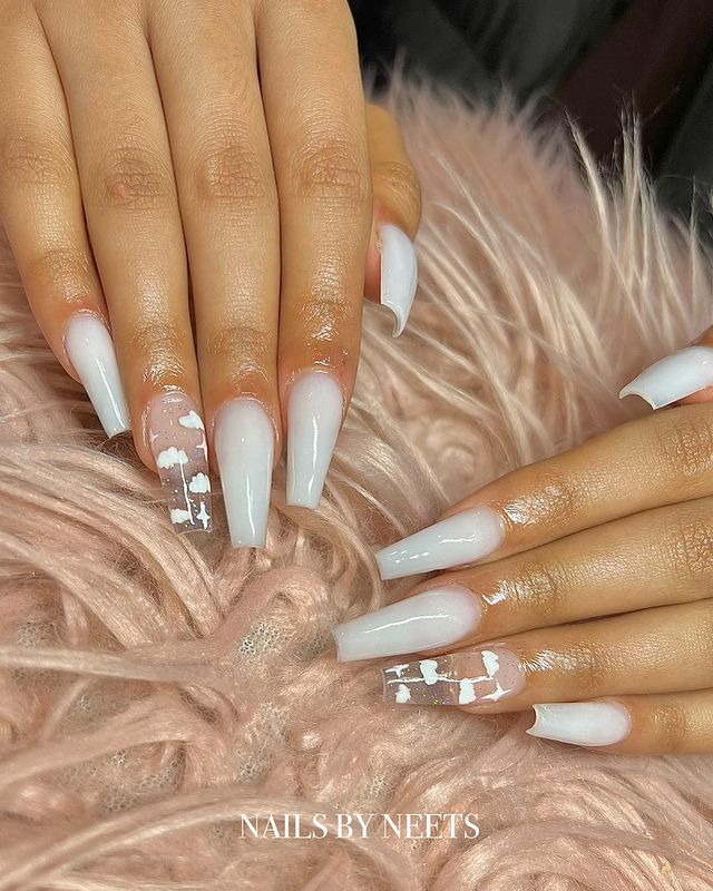 unhas brancas decoradas com nuvens Foto de mãos decoradas com esmalte branca e filha única no dedo anelar com decoração de nuvens.
