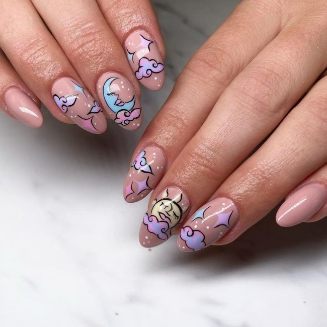 unhas-decoradas-com-nuvens-divertidas Foto de mãos com as unhas com esmalte nude e decoração de nuvens coloridas.