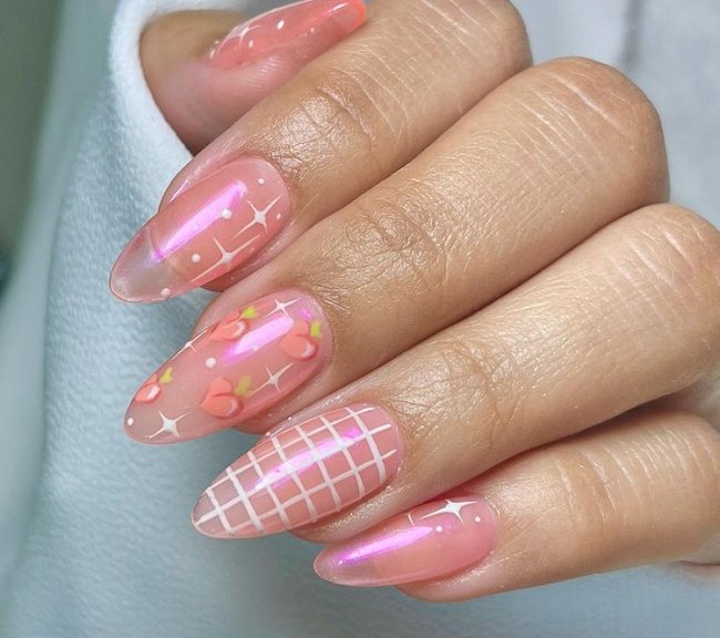 Foto de unhas com efeito jelly e decoração com desenhos de pêssego e outros detalhes brancos.