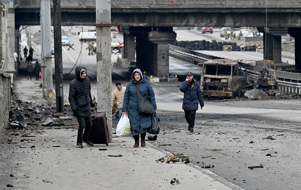 ucrania As pessoas carregam seus pertences enquanto passam pelos escombros do combate das últimas semanas na capital ucraniana de Kiev