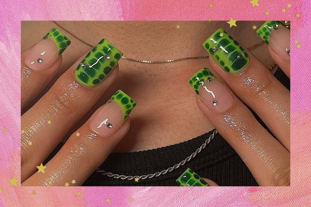 Montagem com o fundo rosa e detalhe de estrelas douradas com a foto de unhas decoradas com estampa de crocodilo no tom verde.