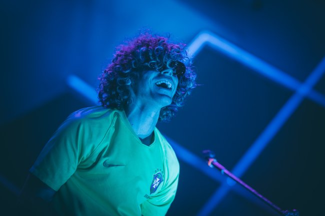 Homem com camiseta do Brasil sorrindo e óculos escuro