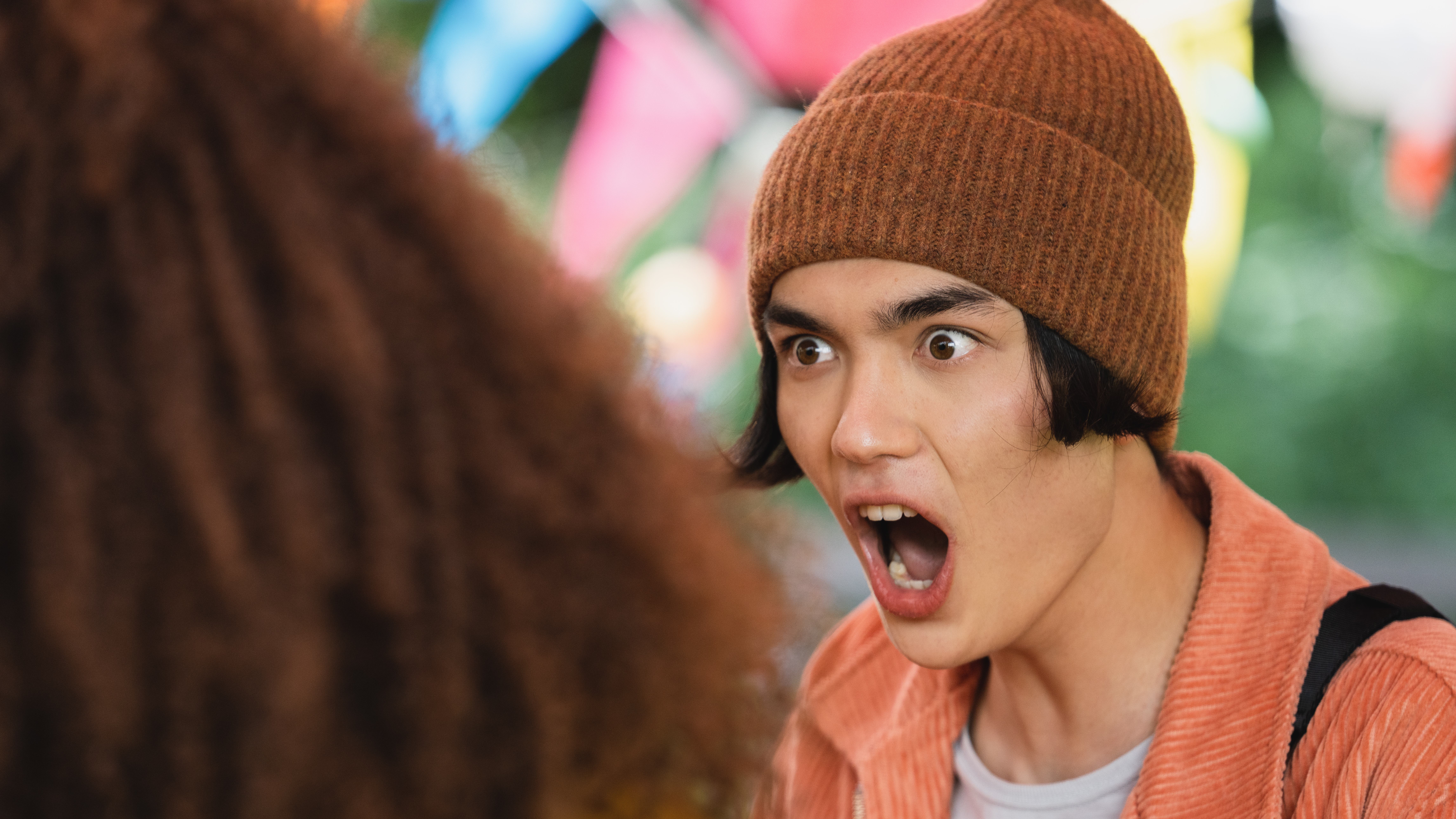 Heartstoppers Season 1 Tao Xu (William Gao) em Heartstopper usando um gorro marrom e com expressão facial de surpresa com a boca aberta