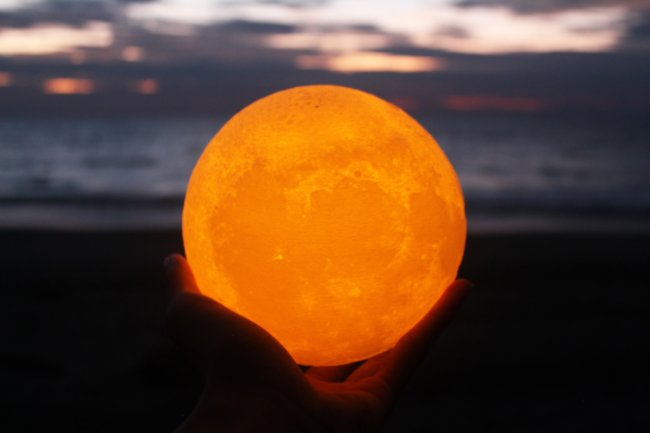 Uma mulher segurando uma lanterna de lua cheia nas mãos