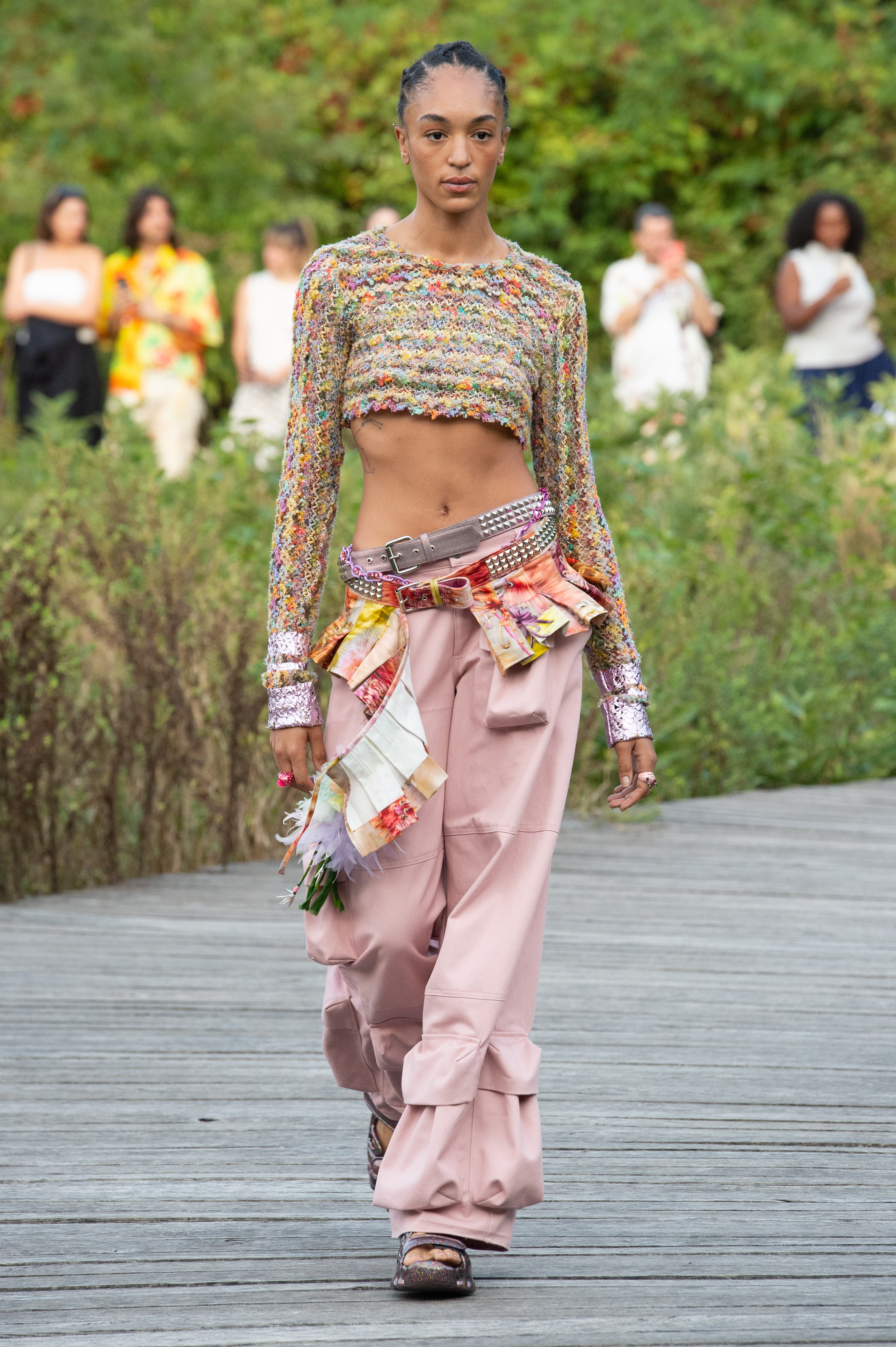 Collina Strada – Runway – September 2022 New York Fashion Week: The Shows Desfile de primavera-verão 2023 da Collina Strada na semana de moda de Nova York. Modelo usando top cropped colorido, calça rosa de cintura baixa e dois cintos