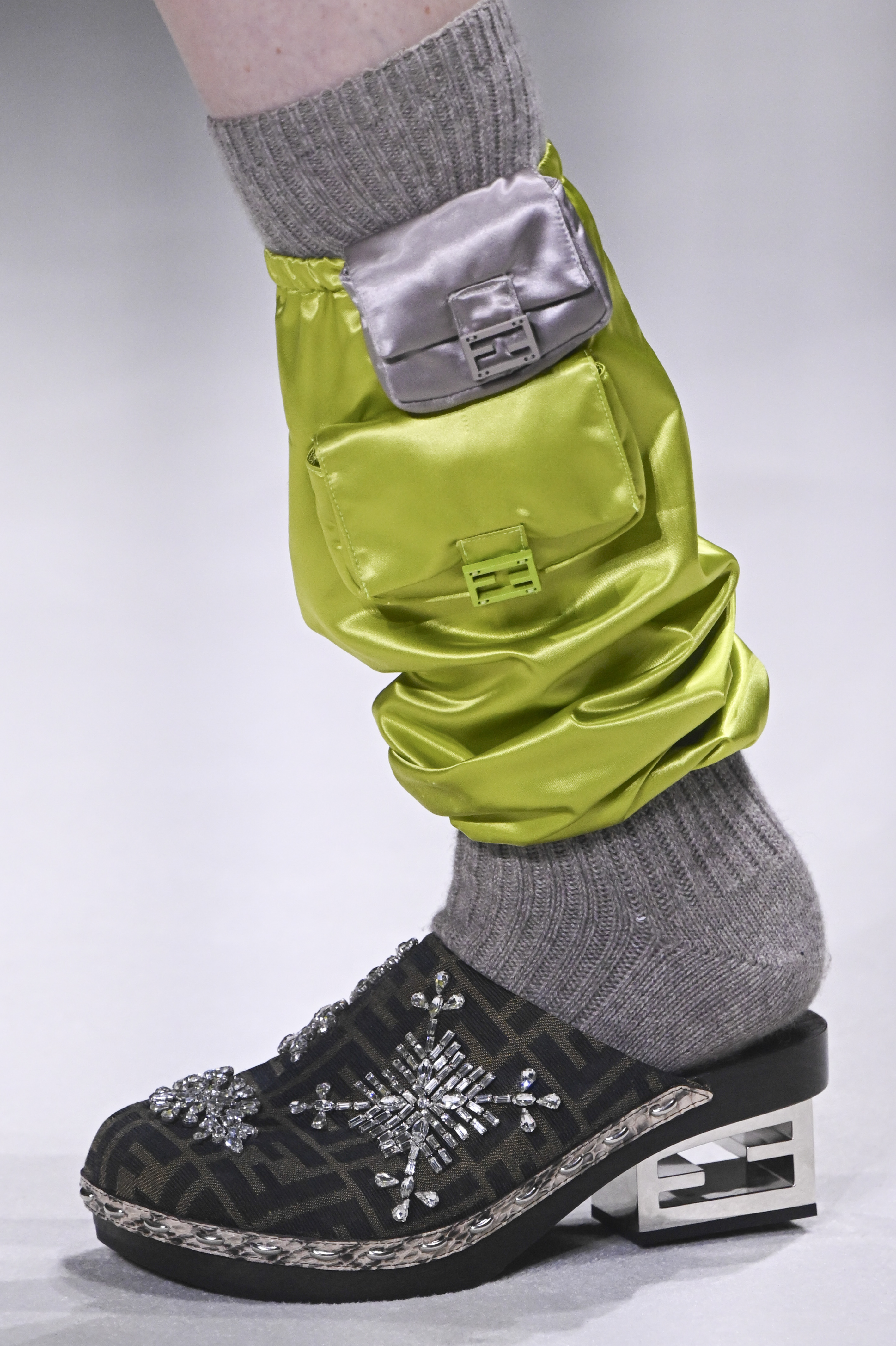 Fendi – Runway – Spring/Summer 2023 New York Fashion Week Desfile de primavera-verão 2023 da Fendi na semana de moda de Nova York. Pé de modelo usando sapato clog com meia cinza e polaina verde neon com duas minibolsas acopladas