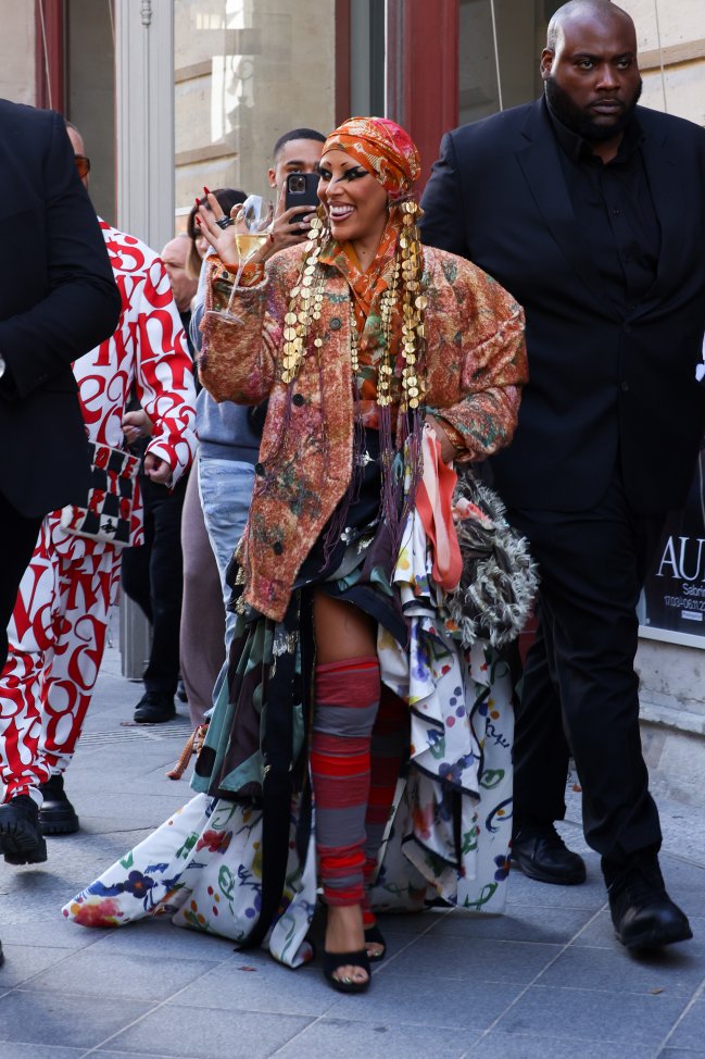 Foto da Doja Cat na Semana de Moda de Paris com um look com diversas peças e estampas.