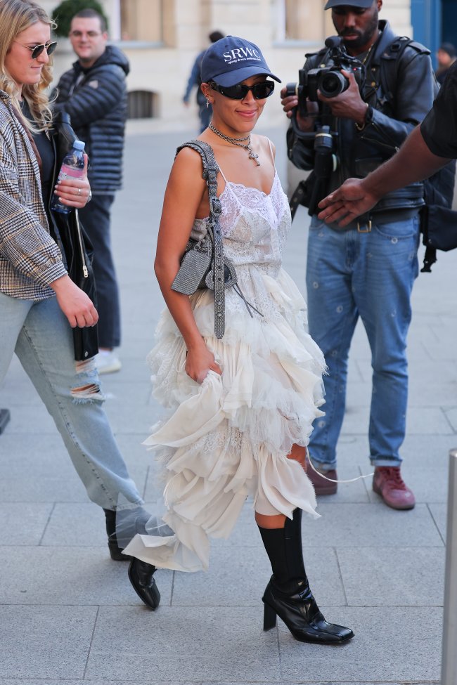 look-vestido-branco-doja-cat-semana-de-moda-de-paris Foto da Doja Cat na Semana de Moda de Paris com um vestido branco e bota de cano alta preta.