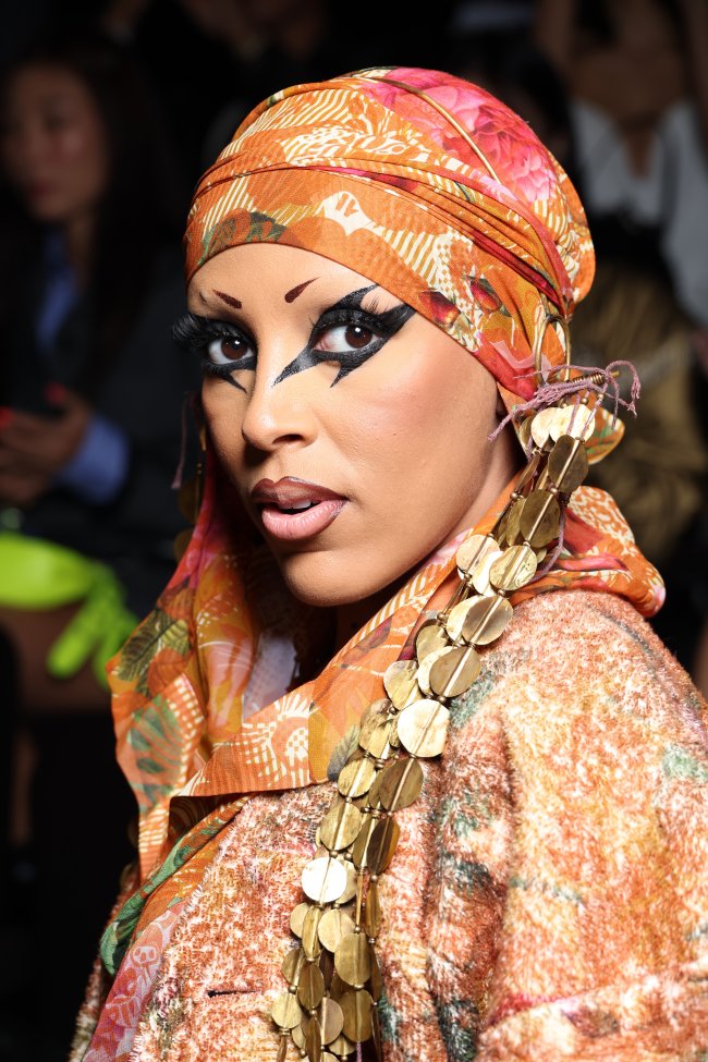 maquiagem-delineado-grafico-doja-cat-semana-de-moda-paris Foto close na maquiagem com delineado gráfico preto da Doja Cat na Semana de Moda de Paris. Ela olha para a câmera e não sorri.