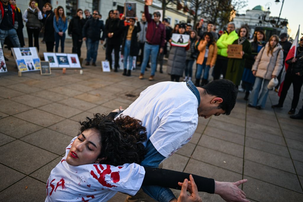 Mulher é carregada por um homem durante protestos pela liberdade das mulheres no Irã