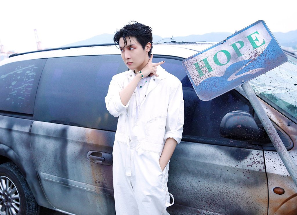 J-Hope posando para foto em frente a um carro