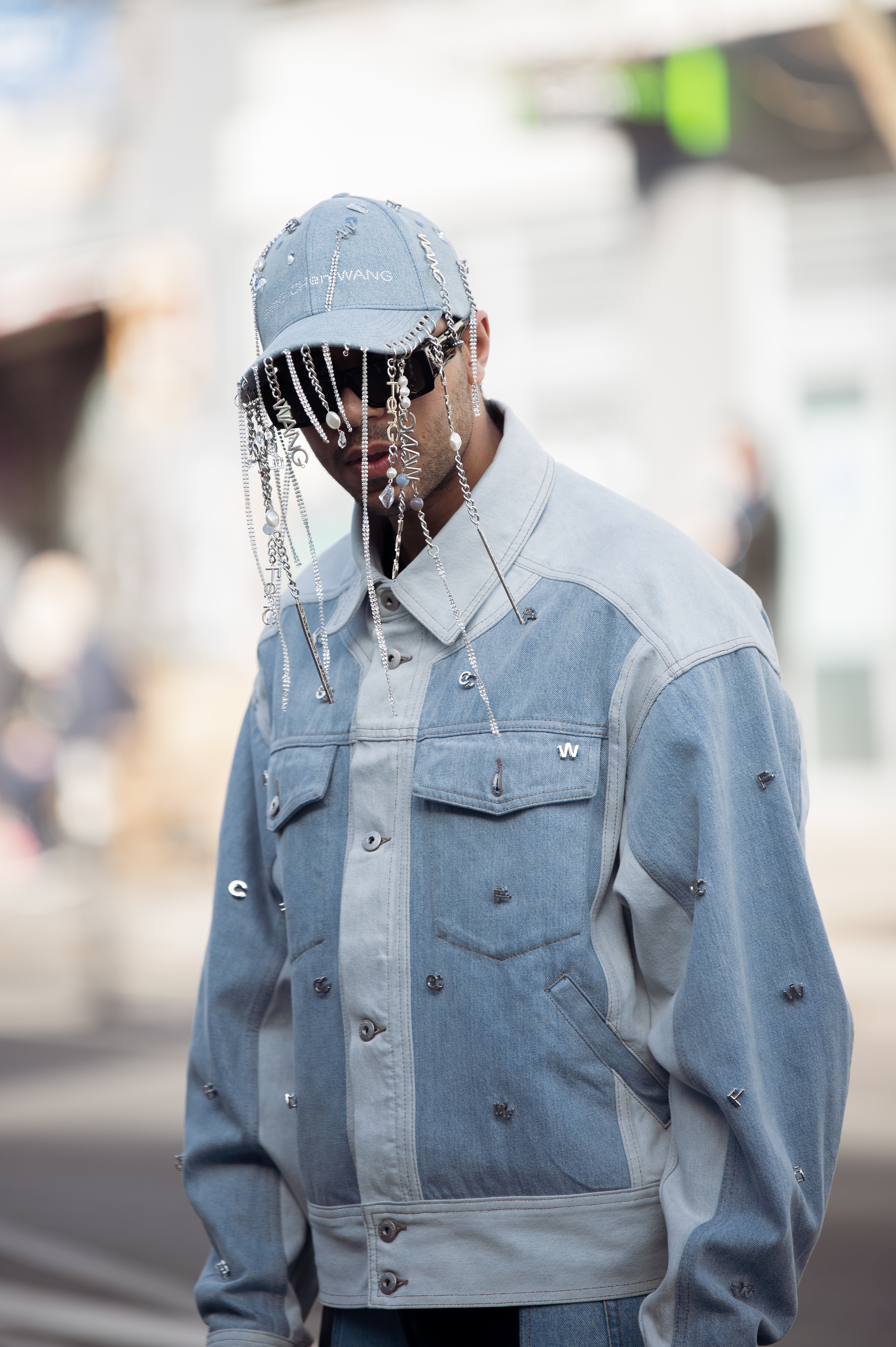 Homem usando look jeans com boné jeans que possui aplicações de strass no street style da semana de moda de Londres