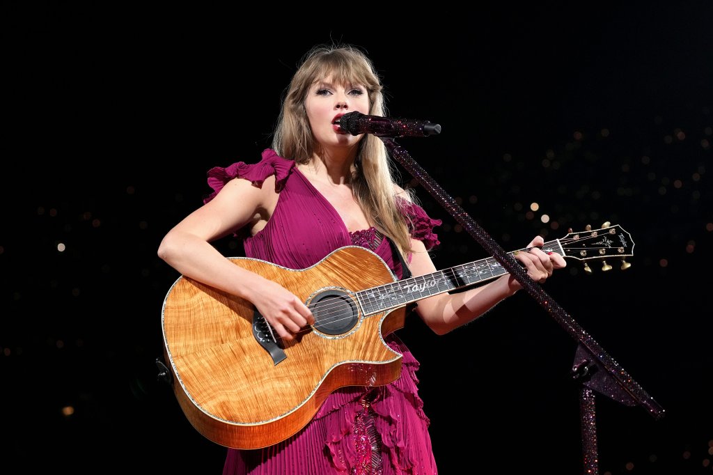 Taylor Swift no primeiro show da The Eras Tour tocando violão e usando vestido na cor vinho