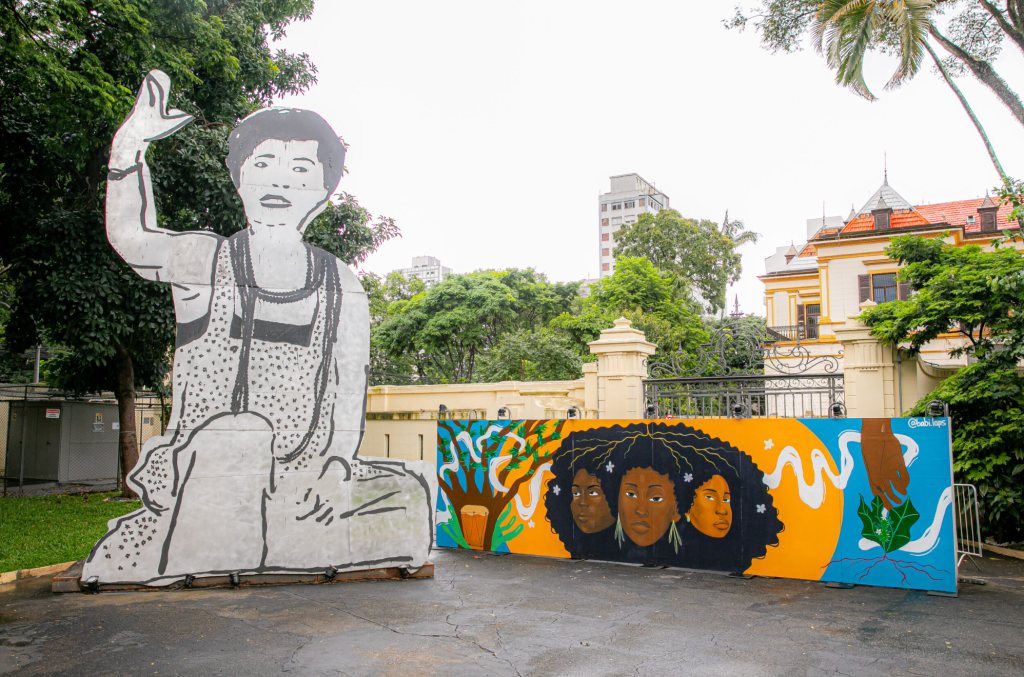 Exterior de prédio, com grafite colorido de três mulheres pretas