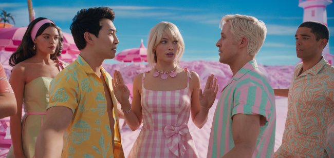 rev-1-BAR-TT2-008_High_Res_JPEG Simu Liu, Margot Robbie e Ryan Gosling em cena de Barbie; Simu e Ryan estão se encarando enquanto Margot está entra os dois com as mãos levantadas