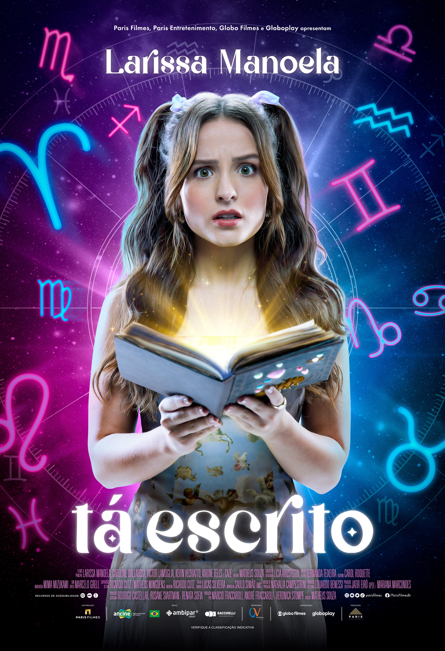 4039A4A4-D926-464C-B20B-EF309BEDE181 Larissa Manoela em pôster de Tá Escrito; ela está com expressão de surpresa e confusão enquanto segura um livro; símbolos de signos do zodíaco estão ao fundo da imagem nas cores rosa, azul e roxo; o nome do filme aparece em branco na parte central inferior da imagem