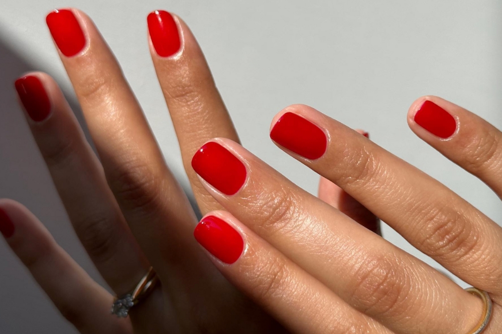 Mão com unhas pintadas de vermelho