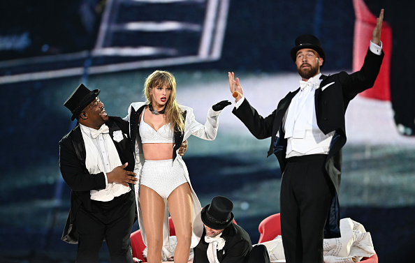 Taylor Swift e seu namorado, Travis Kelce se apresentando com roupas preto e brancas.