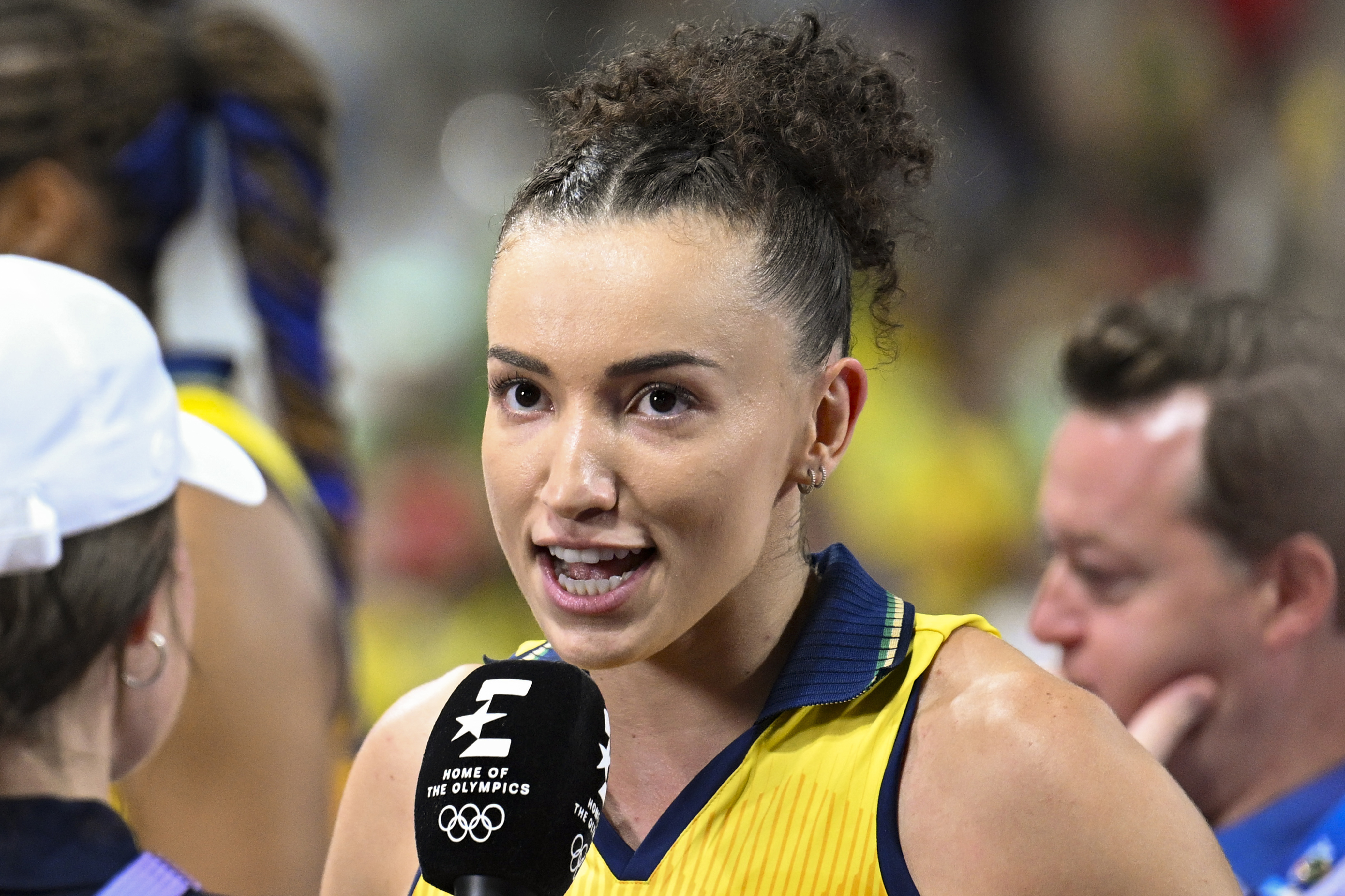 Imagem da jogadora de vôlei Gabriela, vestindo uniforme amarelo e dando entrevista.