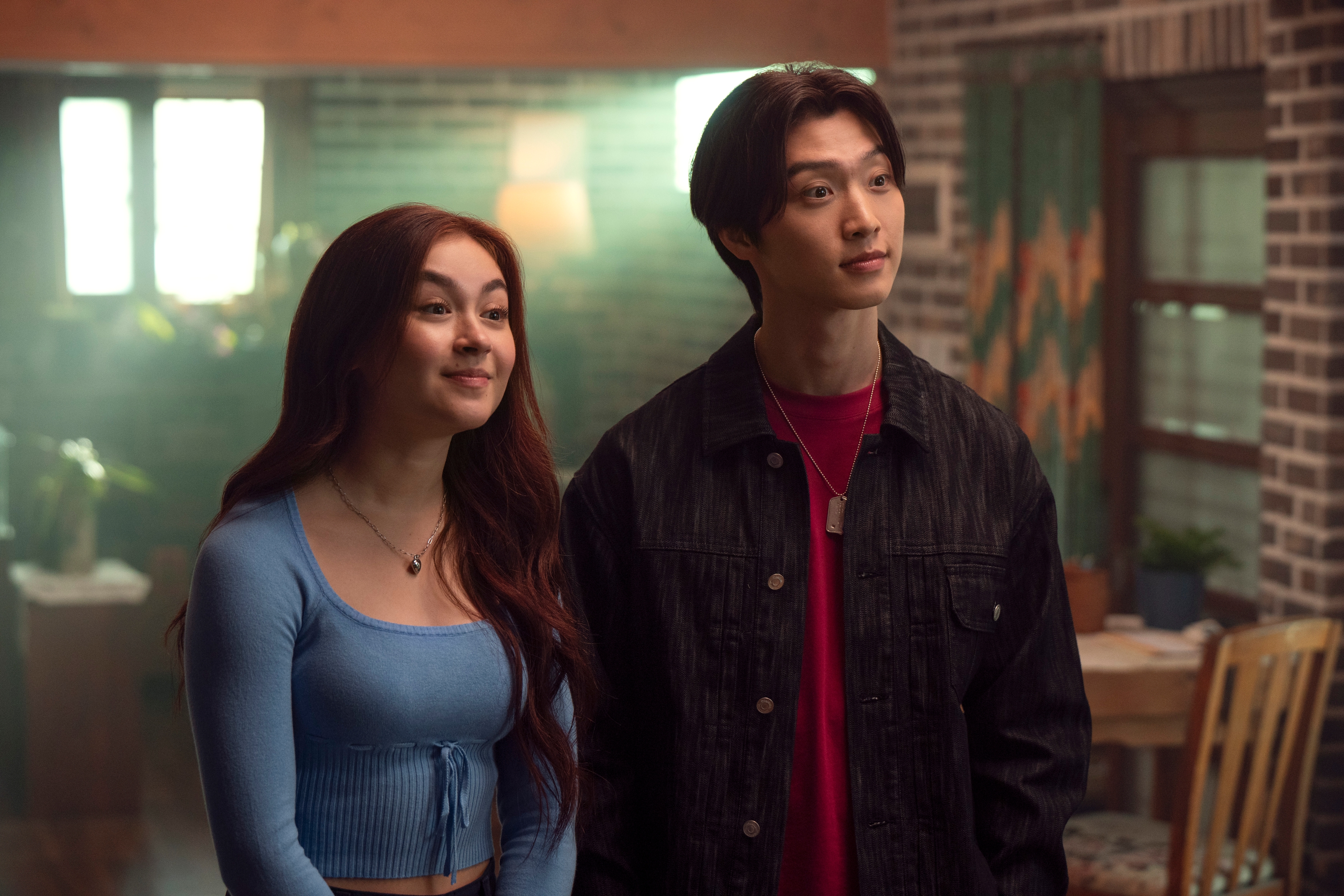 IMG_2764 Anna Cathcart como Kitty Song Covey, Sang Heon Lee como Min Ho em Com Carinho, Kitty; eles estão parados e olhando para frente lado a lado