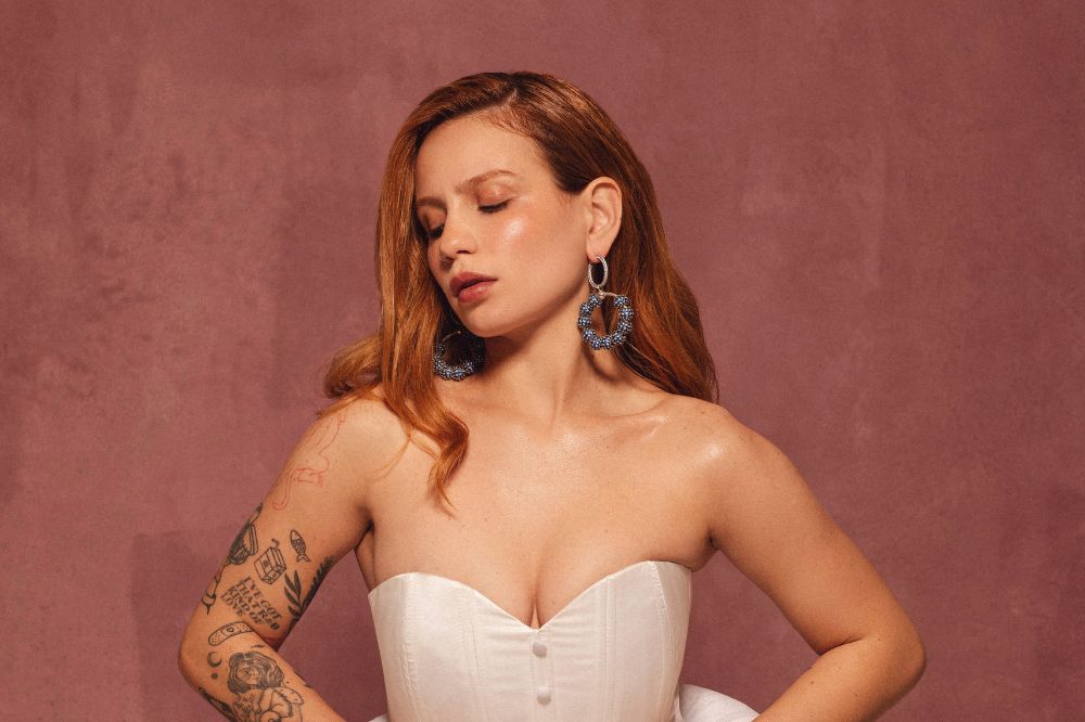 Carol Biazin posando para foto com conjunto branco e meias na cor azul