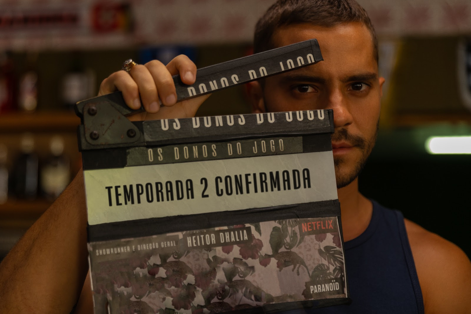 André Lamoglia segurando claquete com o escrito “Temporada 2 confirmada”