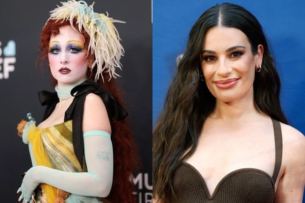 Duas mulheres em close-up. À esquerda, uma mulher com maquiagem teatral, cabelo ruivo volumoso e penas claras na cabeça. À direita, uma mulher sorrindo com cabelo castanho solto e blusa escura